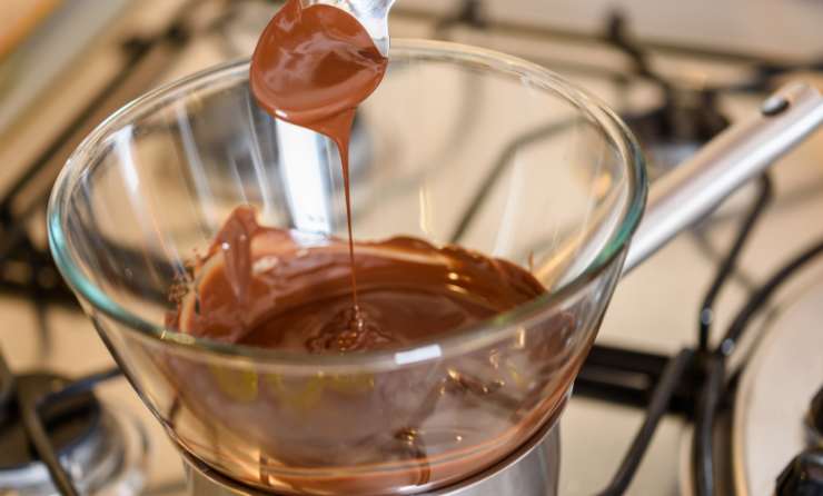 Andiamo a tritare e sciogliere il cioccolato a bagnomaria: possiamo usare il fondente o quello che preferiamo, ma anche servirci di vari gusti così da avere alberelli di vari colori e sapori;