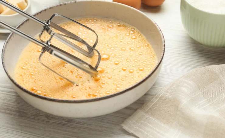 In una ciotola andiamo a rompere le uova e uniamo lo zucchero. Lavoriamo con un frullino fino a rendere il composto ben spumoso (dovrà quasi sembrare raddoppiato). Accorpiamo quindi l’olio, mescolando per inglobare alla crema;