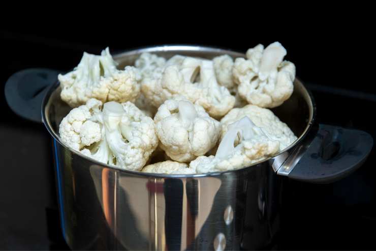 Comincia a pulire il cavolfiore eliminando le foglie esterne e le parti più dure. Ricava le cimette e sciacquale sotto l’acqua corrente. Sbollentale in acqua salata per 8-10 minuti e poi scolale e tieni da parte l’acqua di cottura. In una ciotolina a parte, metti in ammollo l’uvetta e sciogli lo zafferano in poca acqua calda.