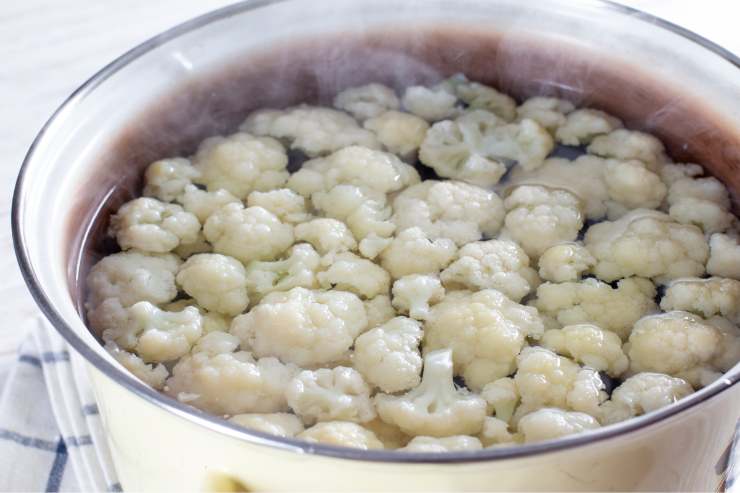 Comincia a pulire il cavolfiore eliminando le foglie e le parti esterne più dure. Ricava le cimette e sciacquale sotto l’acqua corrente. Dopodiché, sbollentale in acqua salata per 10 minuti. Quando saranno ancora al dente, trasferiscile in una padella e saltale velocemente per farle colorire. Aggiungi anche la fontina tagliata a pezzetti, aspetta che si sciolga e poi spegni il fuoco e tieni tutto da parte.