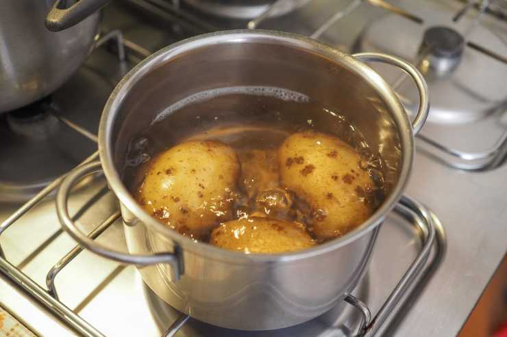 Metti sul fuoco una pentola d’acqua fredda con dentro le patate con tutta la buccia e lessale per 30-40 minuti o fino a quando non saranno diventate morbide. Una volta pronte, scolale e sbucciale senza scottarti e poi passale con un passaverdura.