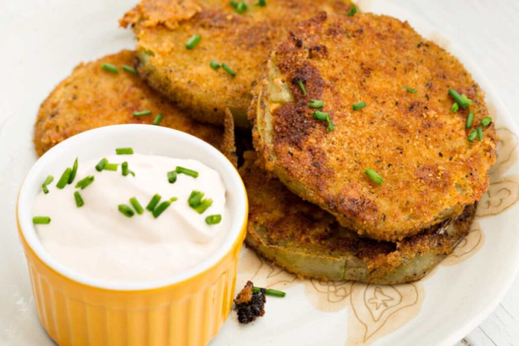 pomodori fritti su tagliere con ciotola di salsa bianca