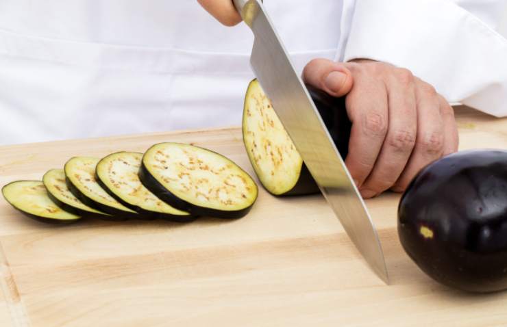 Iniziamo lavando le melanzane e sputiamole, poi tagliamole a fettine tonde non troppo spesse, seguendo il senso della larghezza e cerchiamo di ottenere un numero pari di fettine di melanzane perché dovremmo accoppiarle a due a due come fossero un panino;