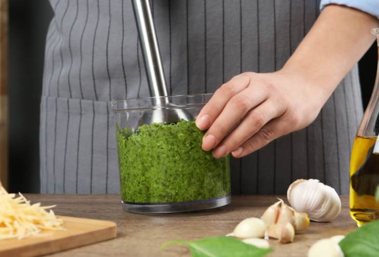 Una volta che le mandorle saranno fredde riversiamole in un frullatore o lavoriamo usando un frullino a immersione unendo le foglie di basilico, i pinoli e il parmigiano. Accorpiamo l’olio a filo e lavoriamo fino ad ottenere una crema omogenea, quindi aggiustiamo il sale;