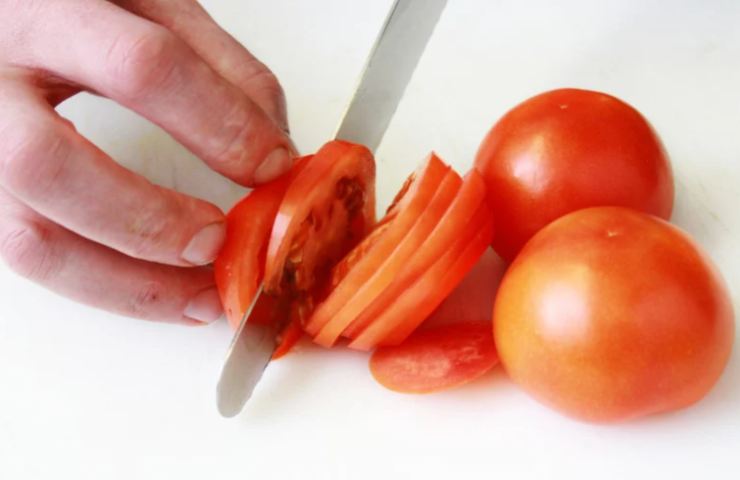 Iniziamo lavando i nostri pomodori e andando a tagliarli a fettine non troppo sottili, teniamoci sul mezzo centimetro. Sgoccioliamo le fettine dall’acqua in eccesso e tamponiamo con della carta assorbente per asciugarli al meglio;