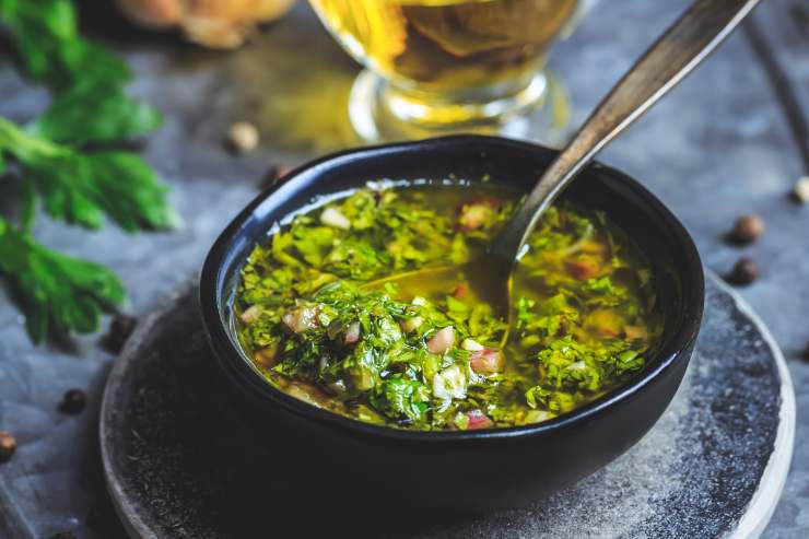 In una ciotolina a parte, prepara il condimento. Schiaccia uno spicchio d’aglio sbucciato e privato dell’anima. Aggiungi il prezzemolo fresco tritato al coltello, l’olio extravergine d’oliva, il sale, il pepe ed il succo di limone filtrato. Emulsiona il tutto con l’aiuto di una forchetta e poi versa la salsa ottenuta sul radicchio grigliato. Lascialo insaporire per almeno mezz’ora e poi portalo in tavola.