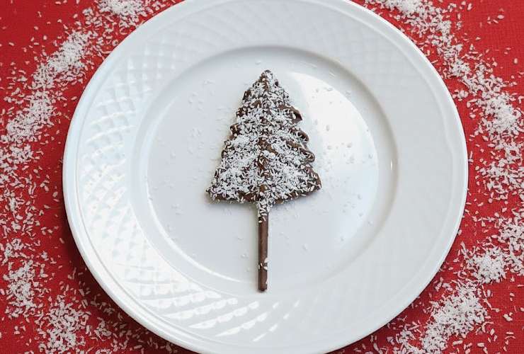 Spolveriamo adesso i confettini colorati o la granella di cocco, gli zuccherini o ciò che preferiamo a nostro gusto. Ripetiamo i passaggi fino a finire i mikado e il cioccolato e aver realizzato il numero di alberelli che vogliamo e ci servono. Mettiamo la teglia in frigo o in freezer e lasciamo rassodare per bene il cioccolato. Al momento di apparecchiare andremo a staccare con delicatezza gli alberelli dalla carta da forno.