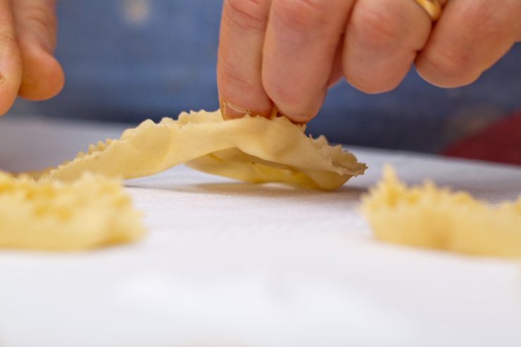 Dopodiché, stendi la pasta a mano o con l’apposita macchinetta in sfoglie sottili (1 mm) e ricava dei rettangoli lunghi 30 cm e larghi 4. Pizzica le strisce ogni 6 cm circa, chiudendole a tratti per il senso della lunghezza. Arrotola poi la striscia su se stessa, in modo da formare una spirale e fissala perché non si apra.