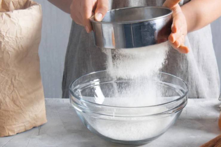 In una ciotola setacciamo le polveri: farina, lievito e zucchero, poi la vanillina;