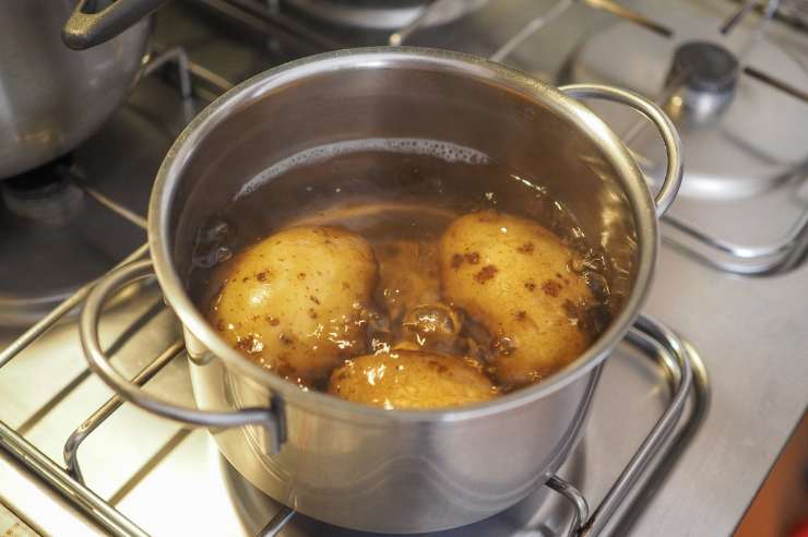 Per prima cosa, sciacqua le patate e mettile a bollire in una pentola d’acqua leggermente salata con tutta la buccia. Ci vorranno circa 30-40 minuti. Una volta pronte, scolale e schiacciale all’interno di una scodella con l’aiuto dello schiacciapatate, in modo che venga via anche la buccia. Unisci il burro, il latte tiepido, il parmigiano grattugiato, il pepe ed il sale, se serve, ed amalgama il tutto.