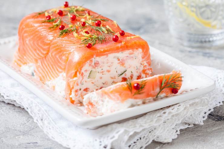 Copri, quindi, con la pellicola e lascia riposare la mattonella in frigo fino al momento di servire. Trascorso il tempo necessario, riprendi la mattonella di salmone, tirala fuori dallo stampo, rimuovi la pellicola trasparente e decora la superficie con qualche ciuffo di aneto e del pepe rosa in grani. Infine, porta in tavola la mattonella intera oppure tagliala a fette.