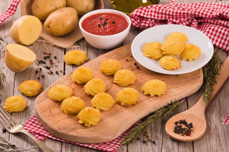 Su una teglia coperta con uno strato di carta da forno, forma dei ciuffi di patate non troppo grandi e nemmeno troppo piccoli, ben distanziati gli uni dagli altri, e cuoci in forno preriscaldato ventilato a 180 gradi per 15-20 minuti. Una volta che le patate duchessa saranno belle dorate, tirale fuori e servile calde.