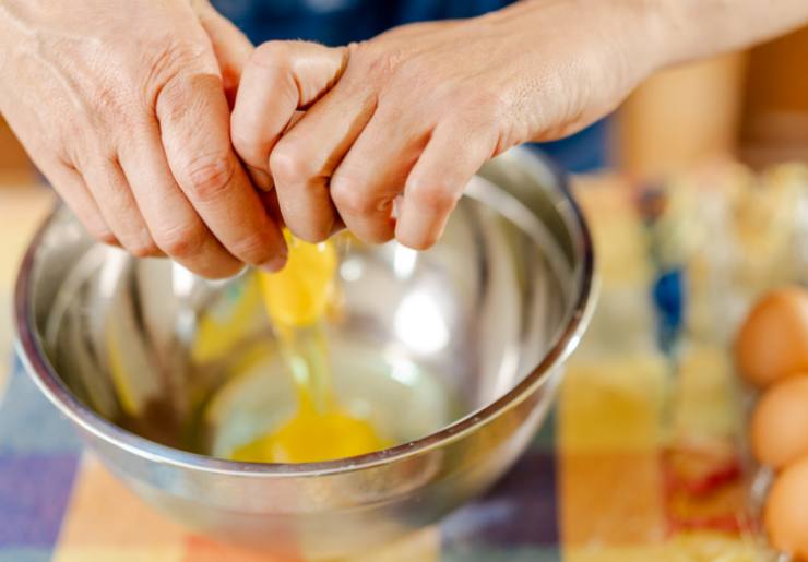 In un secondo tegame rompiamo le uova e accorpiamo il latte, quindi lavoriamo con un frullino, quindi andiamo a setacciare le polveri nel composto di uova e latte