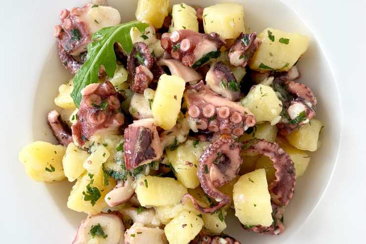 Quando il polpo si sarà raffreddato, taglialo a pezzetti grandi come le patate e mettilo in una scodella capiente. Emulsiona in una ciotolina l’olio extravergine d’oliva, il prezzemolo fresco tritato al coltello, il succo di limone, il sale e il pepe, aiutandoti con una forchetta o una frusta. Infine, unisci le patate al polpo e condisci tutto con la citronette appena realizzata. Mescola delicatamente e lascia riposare l’insalata in frigo per un paio d’ore prima di servire.