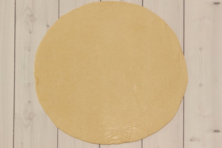 Srotola il primo rotolo di pasta sfoglia e sistemalo con la sua carta da forno su una teglia circolare, grande circa 22 cm di diametro. Versaci sopra metà delle lenticchie avanzate e poi il cotechino a fette o a pezzettini. Completa con le lenticchie rimaste e copri il tutto con il secondo rotolo di pasta sfoglia.