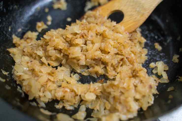 Sbuccia e trita finemente la cipolla e falla appassire in un tegame a fuoco dolce per circa 5 minuti con il midollo e 20 grammi di burro. Dopodiché, aggiungi il riso e fallo tostare a fuoco vivace per un minuto, mescolando.