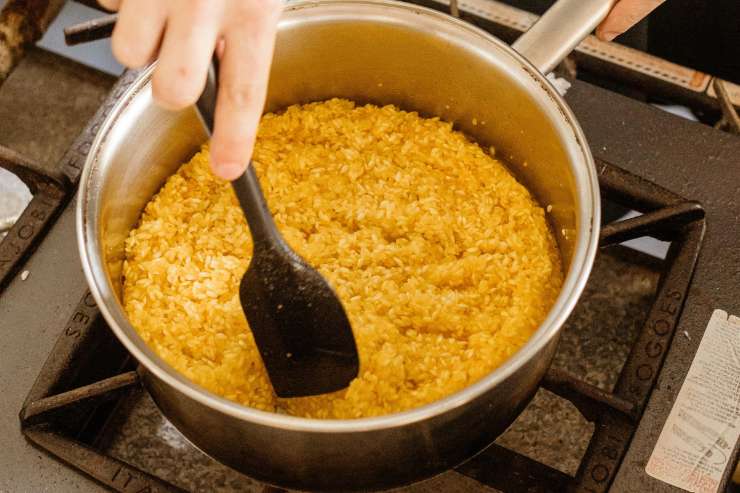 Sfuma tutto con il vino bianco e, una volta evaporato l’alcol, aggiungi un poco di brodo bollente alla volta fino a portare il riso a cottura, sempre mescolando di tanto in tanto. Ci vorranno circa 16-20 minuti in totale.