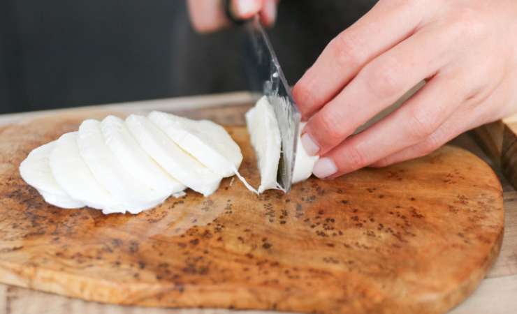 Per prima cosa, taglia la mozzarella a cubetti e mettila a sgocciolare all’interno di un colino. Dopodiché, stendi i due rotoli di pasta sfoglia e ricava dei dischi con l’aiuto di un coppa grande circa 12 cm di diametro.