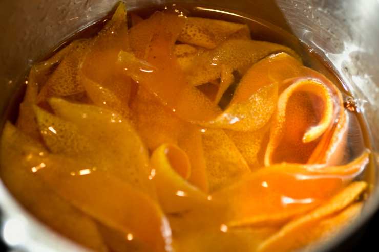 Dopodiché, scolale e trasferiscile in una scodella con acqua fredda e ghiaccio per raffreddarle. Ripeti il procedimento per 4 volte e poi mettile in una pirofila. Versa acqua e zucchero in un pentolino e porta di nuovo a bollore. Quando avrai ottenuto uno sciroppo, aggiungi le scorze d’arancia e falle sobbollire per circa 30 minuti.