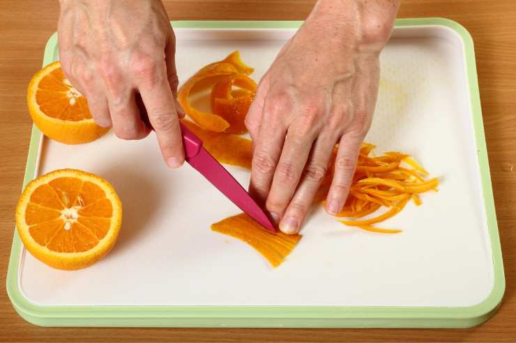 Per prima cosa, lava le arance e tagliale a spicchi tenendo la buccia. Poi, con un coltello, separa la polpa e taglia la buccia a striscioline spesse circa mezzo centimetro, seguendo il verso degli spicchi. Metti, quindi, le scorze in un pentolino con l’acqua e porta a bollore.