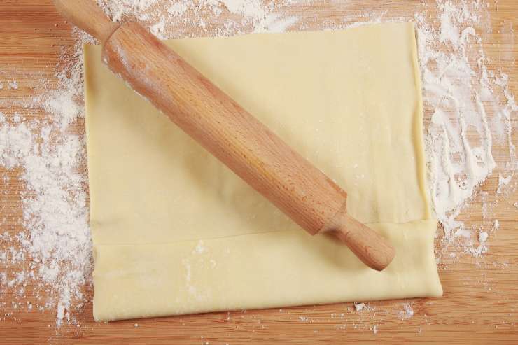 Quando i funghi saranno pronti ed il liquido di cottura sarà evaporato, spegni il fuoco e stendi il rotolo di pasta sfoglia. Cospargilo con la fontina tagliata a cubetti piccoli, aggiungi i funghi con i porri e infine il prosciutto cotto a dadini. Arrotola, quindi, lo strudel su se stesso partendo dal lato più corto e sigilla bene i bordi.