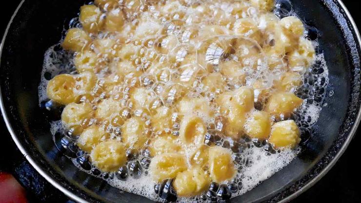 Dividete l’impasto in più porzioni e ricavate dei filoncini sottili dello spessore di circa un centimetro, quindi tagliateli a tocchetti molto piccoli: più sono ridotte le dimensioni, più verranno morbidi dentro ed uniformi fuori. Scaldate abbondante olio in una casseruola e friggete pochi pezzi alla volta, girandoli finché diventano dorati, poi scolateli su carta assorbente.