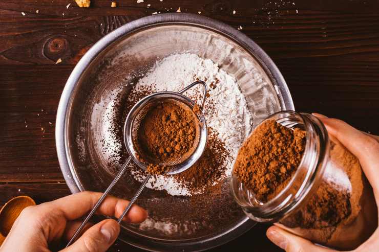 Per prima cosa, scalda dolcemente il miele in un pentolino insieme ad un goccio d’acqua e mescola in modo da farlo sciogliere. In una scodella a parte, setaccia la farina, il lievito ed il cacao amaro in polvere. Unisci la cannella, lo zucchero e il latte a temperatura ambiente e poi incorpora anche il miele tiepido. Amalgama quindi con le mani fino ad ottenere un composto omogeneo.