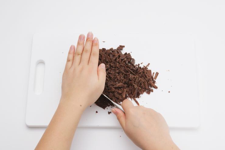 Trita il cioccolato al coltello e fallo sciogliere nel microonde o a bagnomaria. Lascialo raffreddare e, a parte, sbatti con delle fruste elettriche il burro morbido insieme allo zucchero per circa 10 minuti, fino ad ottenere un composto chiaro e spumoso. Unisci il miele ed aggiungi le uova una alla volta.