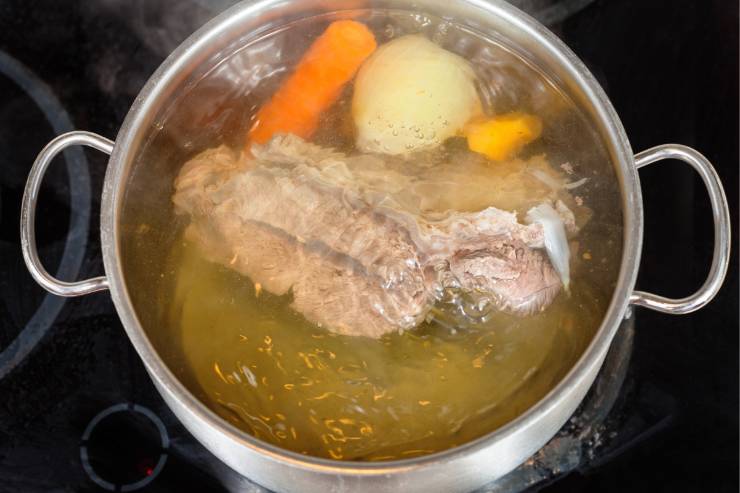 Per prima cosa, prepara il brodo. Taglia la cipolla a metà e falla rosolare in padella. Sala le carni e mettile in una pentola con acqua fredda. Aggiungi la cipolla, le carote pelate e la costa di sedano pulita e porta tutto ad ebollizione. Elimina la schiuma in superficie ed abbassa la fiamma, in modo da lasciare sobbollire il brodo. Vai avanti a cuocere per circa 3 ore.