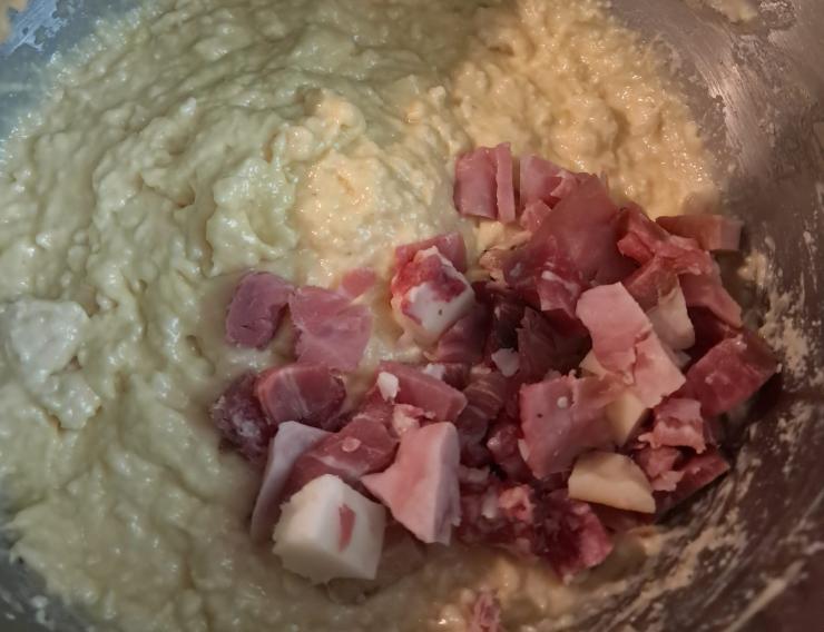 Non preoccupatevi se il composto vi sembrerà molle, è la consistenza giusta! Aggiungete ora poco alla volta il mix di salumi e formaggi a cubetti e quando saranno ben distribuiti, spegnete la planetaria. Imburrate ed infarinate bene uno stampo a ciambella del diametro di 28 centimetri circa e versate l’impasto livellandolo.