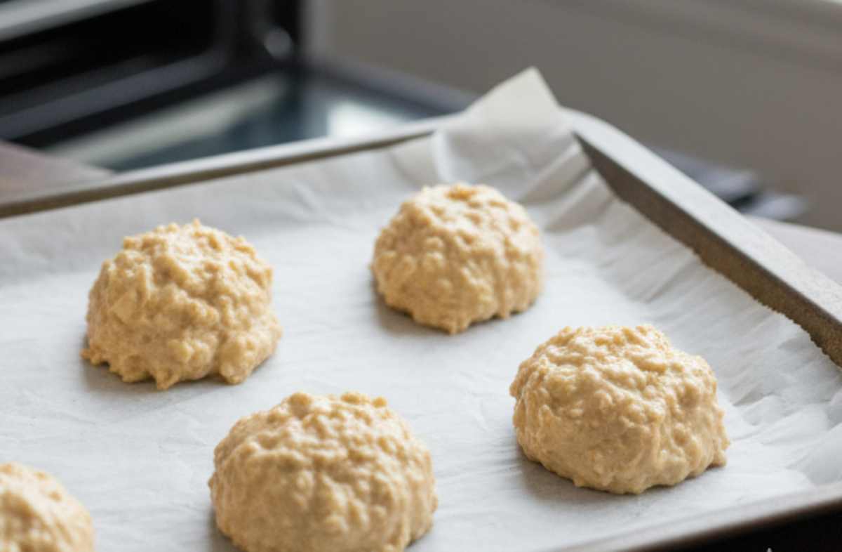 Versate ora le mele: noterete che c’è pochissimo impasto rispetto alla frutta: è normale, è questo il segreto dell’invisibilità! Prelevate un po’ del composto con un cucchiaio, create dei mucchietti su una teglia foderata di carta forno, appiattiteli leggermente e trasferite in forno.