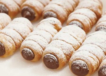 cannoli di pasta sfoglia con cioccolato e ricoperti di zucchero a velo