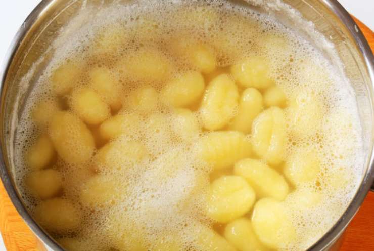 Una volta cotti gli gnocchi andiamo a scolarli e riversiamoli in una padella antiaderente. Uniamo tre o quattro coppini di sugo di pomodoro e mescoliamo, per poi portare sul fuoco a fiamma dolce. Uniamo la mozzarella tagliata a pezzetti e mescoliamo fino a quando inizia a filare;