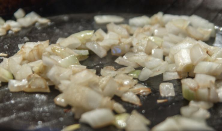 Possiamo scegliere di tagliare i peperoni a fettine o a pezzetti, come più ci piacciono. Intanto andiamo a rosolare, in una padella antiaderente, la cipolla tritata con un filo generoso di olio d’oliva;