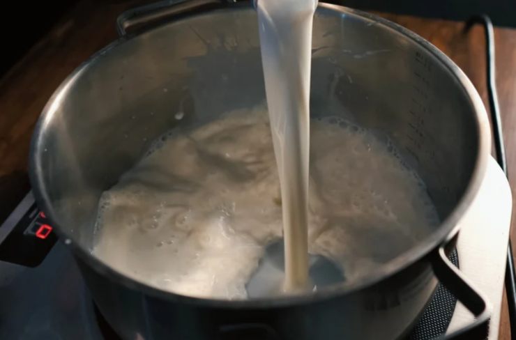 Quando il latte sarà caldo andiamo a riversarlo, a filo, sul composto di polveri e spostiamo il tegame sul fuoco a fiamma dolce. Iniziamo a mescolare con un mestolo di legno lentamente;