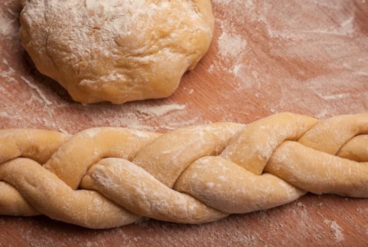 Riprendiamo il panetto e dividiamolo in tre porzioni uguali che dovremo intrecciare per dare la classica forma a treccia: sistemiamo in una teglia da forno foderata e lasciamo lievitare ancora per un’altra ora;