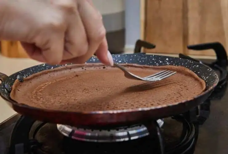 Scaldiamo una padella antiaderente con un cucchiaio di burro e una volta fuso riprendiamo il composto e lasciamo cadere un coppino di crema al centro della padella, livellando sul fondo. Facciamo cuocere la crepes prima da un lato e poi giriamo, come facciamo con la frittata;