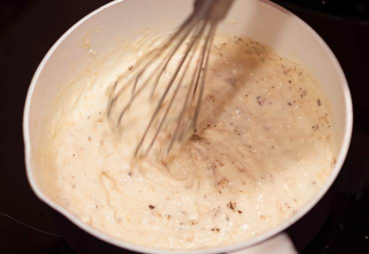 Andiamo ad unire, poco alla volta, le polveri al composto di acqua: setacciamo così da evitare grumi e intanto lavoriamo con un frullino o una frusta a mano fino ad ottenere un composto omogeneo e liscio. Se vogliamo, aggiungiamo ora la vanillina;