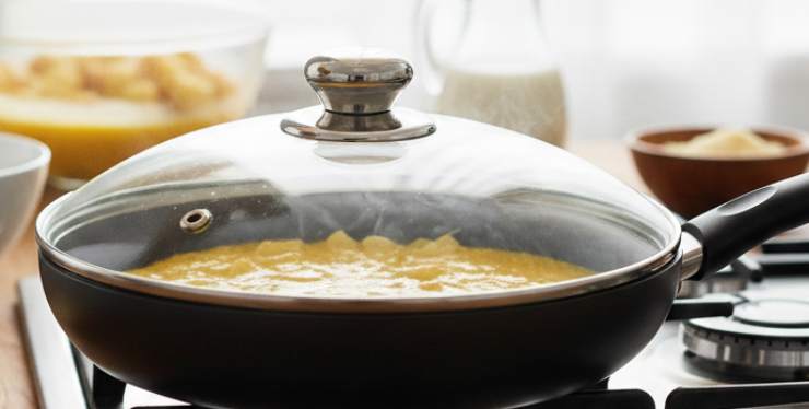 Versate le patate rosolate direttamente nella ciotola con le uova: mescolate delicatamente affinché le patate siano ben distribuite nel composto. Pulite velocemente la padella usata per le patate con un pezzo di carta assorbente, aggiungete un filo d’olio nuovo e scaldate bene. Quando sarà calda, versate tutto il composto, livellate le patate con una spatola e coprite immediatamente con un coperchio a cupola (o uno che chiuda molto bene).