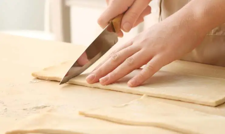 Stendiamo il primo rotolo di sfoglia e tagliamo a rettangoli, dovremo ottenerne circa 6. Ripetiamo con il secondo rotolo di sfoglia;
