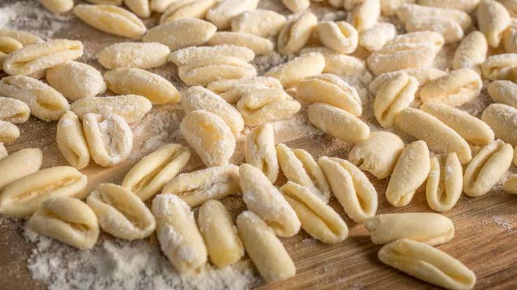 Mettete la semola sulla spianatoia, unite un pizzico di sale e versate gradualmente l’acqua tiepida. Impastate fino ad ottenere un panetto liscio ed elastico: coprite e lasciate riposare 15/30 minuti. Dividete l’impasto in pezzetti, formate dei filoncini sottili e tagliateli a cilindretti: con l’indice trascinate ognuno di essi per dare la forma tipica dei cavatelli.