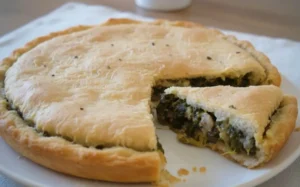 Fetta di pizza rustica napoletana ripiena di salsiccia e friarielli, crosta dorata e ripieno abbondante su tavola in legno