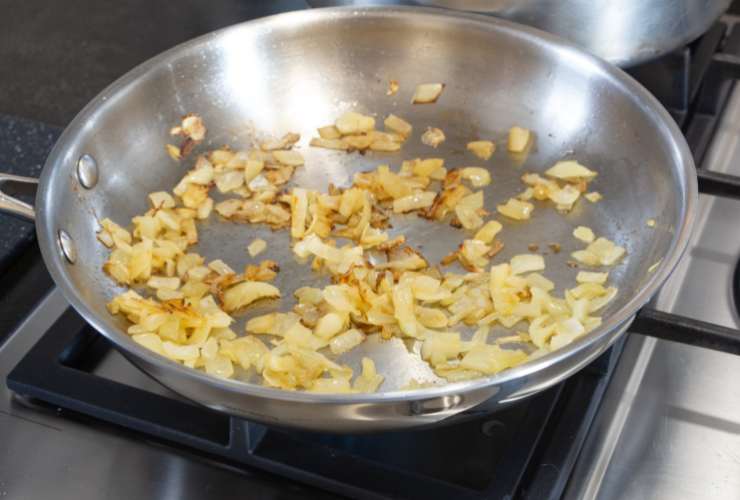 Per prima cosa dovremo sgocciolare i ceci eliminando tutta l’acqua di conservazione. Intanto, in una padella capiente e antiaderente, andremo a riversare un filo abbondante di olio d’oliva e la cipolla tritata finemente;