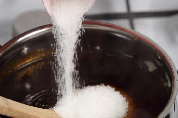 Iniziamo prima di tutto andando a realizzare lo sciroppo in cui immergeremo le chips di mela: riversiamo l’acqua insieme allo zucchero in un tegame e portiamo sul fuoco a fiamma dolce;