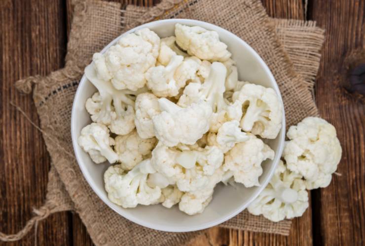 Iniziamo pulendo e lavando il cavolfiore e tagliamolo a cimette più piccole. Sgoccioliamo mentre rosoliamo in una pentola lo spicchio d’aglio con un filo d’olio d’oliva e con il mezzo peperoncino (io tolgo i semi per renderlo meno intenso);