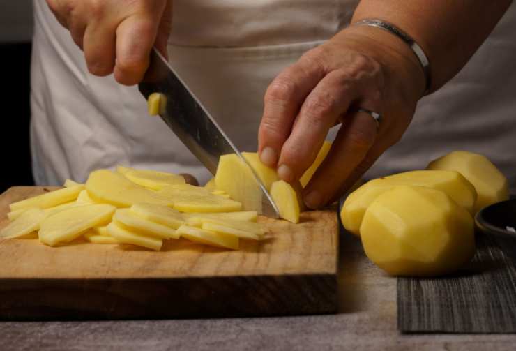 Iniziamo andando a lavare con cura le patate, poi sbucciamole e tagliamole a fettine spesse circa un millimetro (possiamo usare una mandolina);