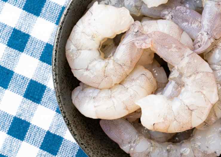 Iniziamo pulendo i gamberetti: andiamo a sgusciarli e tamponiamo via l’acqua in eccesso con della carta assorbente;