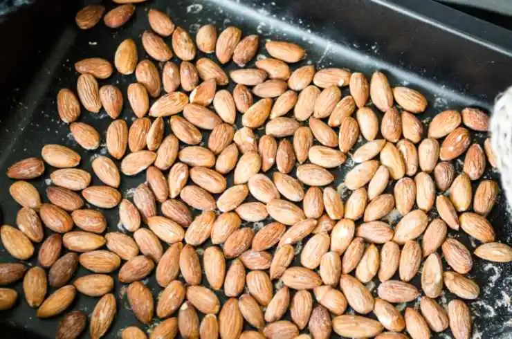 Iniziamo tostando le mandorle pelate: possiamo procedere in padella, in forno o in friggitrice ad aria. Riversiamole quindi in un frullatore e riduciamo in polvere (procediamo poco alla volta per non surriscaldare le lame);