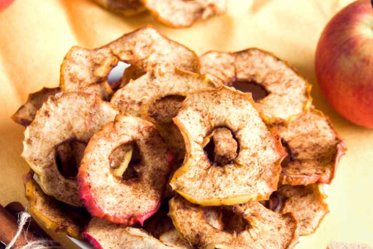 Trascorso questo tempo togliamo la teglia da forno e lasciamo raffreddare completamente le chips di mela (diventeranno croccanti), poi spolveriamole con dello zucchero a velo se di nostro gusto.