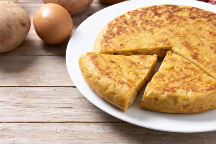 Lasciamo cuocere coprendo con un coperchio e appena il primo lato sarà dorato e compatto capovolgiamo, lasciando cuocere la frittata anche dall’altro lato. Quando la frittata sarà ben cotta spostiamo in un piatto e tagliamo a fette.